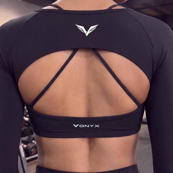 Rear view picture of a woman wearing VONYX CALI Raven women’s gym shrug and sports bra