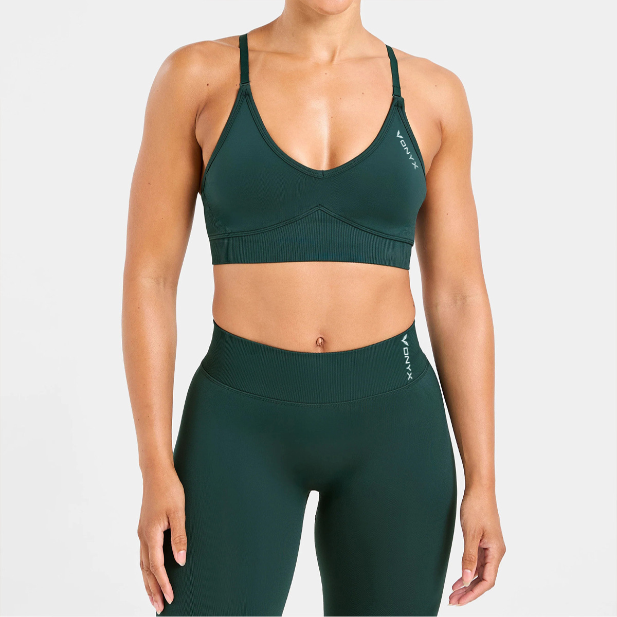 Woman wearing VONYX REFLECT Green sports bra and VONYX REFLECT Green high-waisted women’s gym shorts